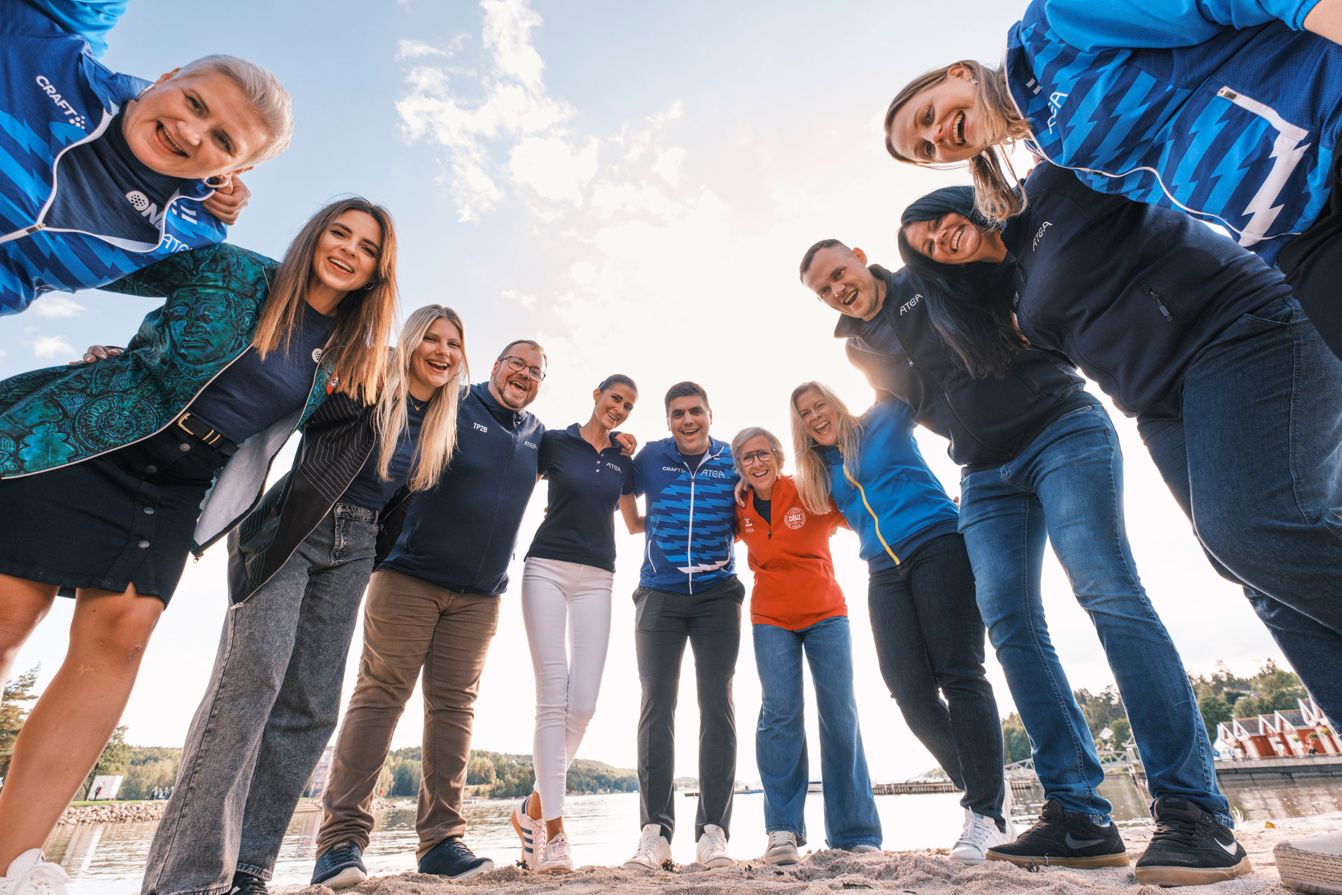 A Ring Of People Standing With Their Arms Around Each Other